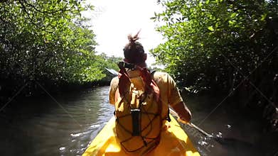 Young lady paddling hard the sea kayak with lots