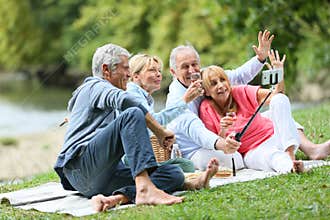 Seniors having fun taking selfie on a pic-nic