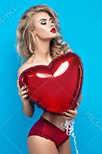Young blond woman in lingerie with heart balloon