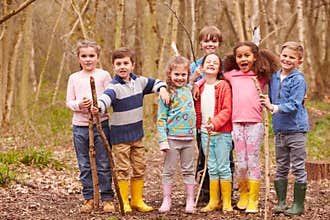 Portrait Of Children Playing Adventure Game In Forest