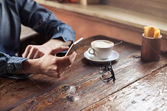 Hipster guy texting with his mobile phone