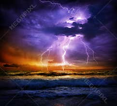 Lightning and storm on sea to the sunset