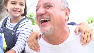 Grandparents Giving Grandchildren Piggyback Ride In Garden