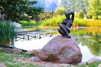 Sculpture bather girl sitting on a rock
