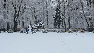 Families with a child make a snowman.