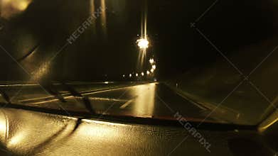 Car driving through the rainy night weather