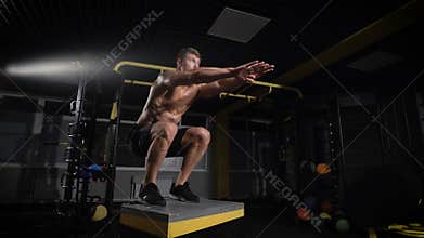 Sportsman working out his body in box jumping