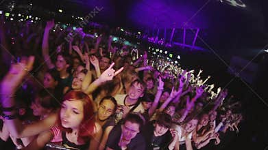 Many people raise hands on live rock concert in crowded nightclub. Spotlights. Excitement