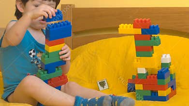 Cute boy playing with toy blocks