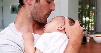Handsome father holding his baby