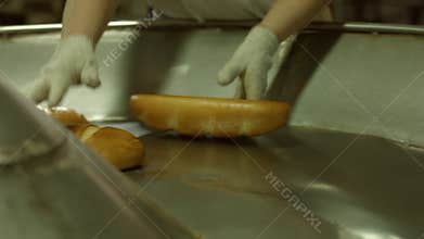 Unloading of bread from the conveyor.