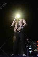 Men on Stage with Intense Golden Glare on his Shades