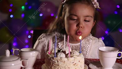 Little girl blowing out the candles of Birthday cake