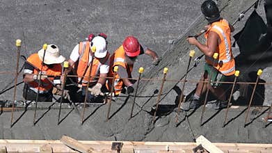 Builders pour cement to a concrete wall