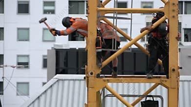 Builders assemble a construction tower crane