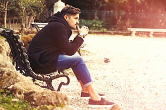 Thinking, thoughtful handsome man on the bench. Outdoors
