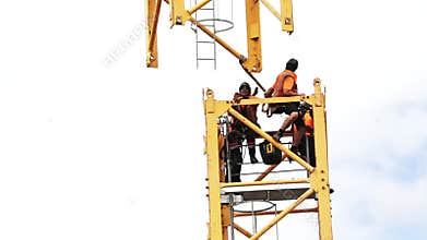 Builders assemble a construction tower crane