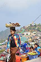A street vendor carrying tray of freshly cooked yam, cassava and alike on her head