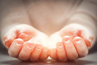 Light in woman's hands. Concepts of sharing, giving, new life