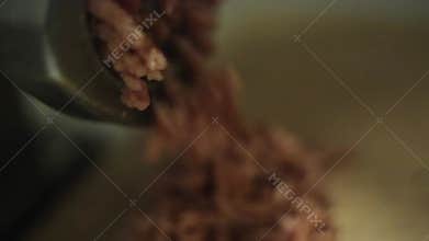 Process of grinding fresh meat on wooden kitchen board by meat grinder. Close up