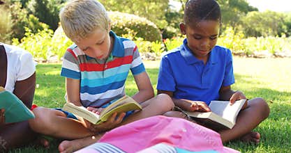 Group of kids reading books in park