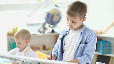 Two brothers draw. Little brothers are busy drawing.