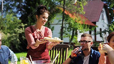 Happy friends having dinner at summer garden party