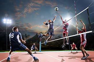 Professional volleyball players in action on the night court