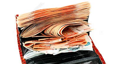 Growing stack of russian rubles in red wallet