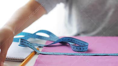 Tailor woman with measuring tape and fabric
