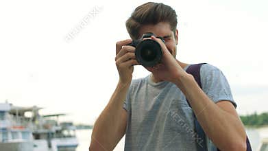 Portrait of professional photographer using his photo camera.