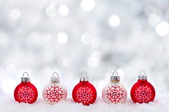 Red and white Christmas ornaments with twinkling silver background