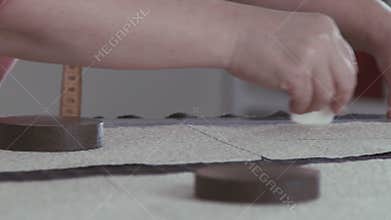 Slowmotion. Cutting fabrics. Woman sews clothes.