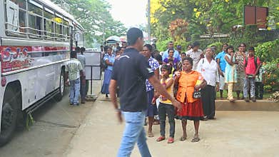 KANDY, SRI LANKA - FEBRUARY 2014: Locals standing at bus station near the Botanical Garden in Kandy.