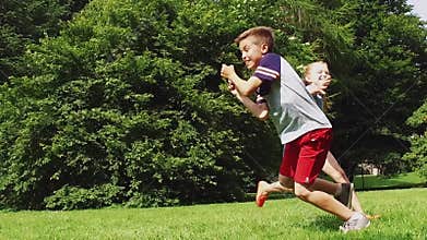 Happy kids running and playing tag game outdoors