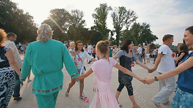 People walking in a circle holding hands