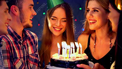 Girl with friends celebrate birthday and blow out candles on cake.4k