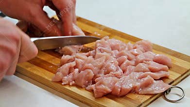 Cutting chicken meat on half close up. cook cutting meat on desk,