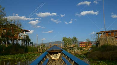 Boat going through floating village, Inle Lake, Myanmar