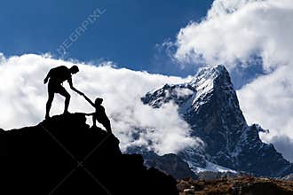 Teamwork couple hikers silhouette in mountains, climbers team