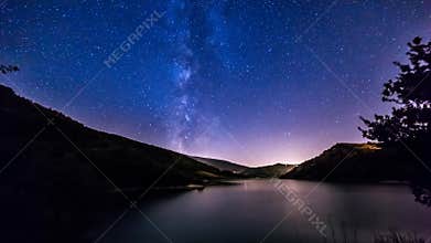 Night sky stars timelapse. milky way on mountain lake landscape