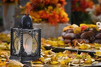 Beautiful autumn concept to the cemetery and Halloween. Candle in a lantern on the grave. Background for Halloween.