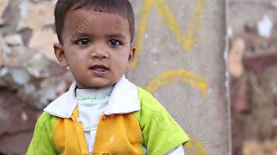 Portrait view of small indian boy pointing with his finger.