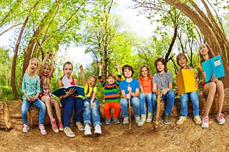 Happy kids reading books outdoor in summer camp