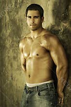 Young bodybuilder against wall