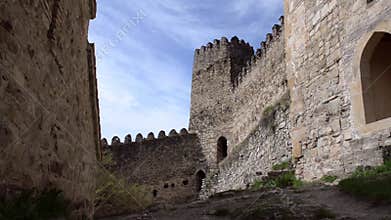 View on the walls of the fortress with a tower on a background of beautiful clouds. Ananuri, Georgia