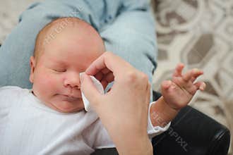 Mother cleaning eyes of a newborn baby