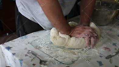 Hands kneading bread dough.
