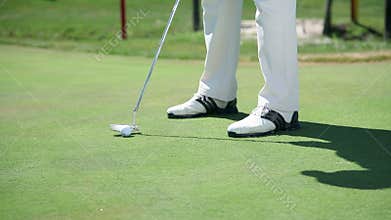 Close up shot on a golfer when hits white golf ball directly to the hall