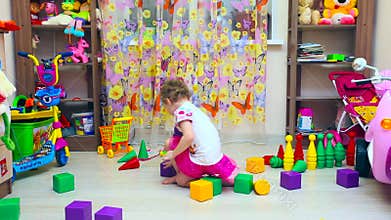 Little girl builds pyramid of blocks